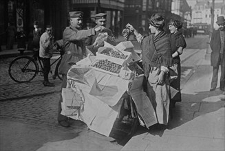 German soldiers purchasing grapes from women with a street cart in Belgium during World War I ca. 1915