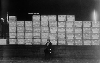 Mrs. George Washington-Lopp (Clara Dolores Machain) sitting in front of a shipment of cigarettes and cigars she arranged to have shipped to soldiers fighting in World War I ca. 1914-1915