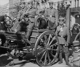 German soldiers seated on a mobile field kitchen in a city street during World War I ca. 1914-1915