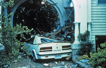 A house on the southern tip of Charleston fared well during the storm. However, the car was not as lucky after passage of Hurricane Hugo ca. September 1989