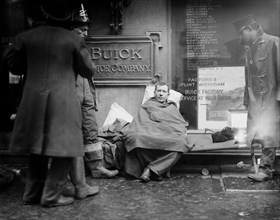 Fireman seated on the sidewalk after fighting a fire in a New York City subway tunnel which took place near West 55th Street and Broadway, January 6, 1915