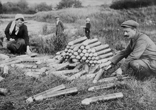 Man and woman looking at artillery shells on the ground in France, after the First Battle of the Marne which took place during World War I - October 29, 1914