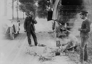 English soldiers cooking and eating next to a truck on the road, during World War I ca. October 1914