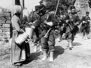 Peasant woman giving water to French soldiers at the beginning of World War I ca. 1914-1915
