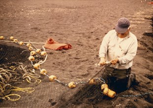 Salmon fisherman repairing nets 7/17/1973 Alaska