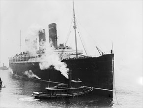 Passenger ship LUSITANIA with tugboat ca. March 1914