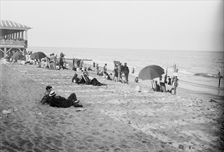 People enjoying a lovely day on the beach in Asbury Park, NJ ca. 1910-1915