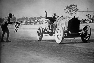 Joe Dawson crossing the finish line as the winner of the Indianapolis 500 automobile race ca. 1912