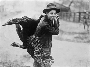 A man carrying home his Thanksgiving turkey ca. 1910-1915