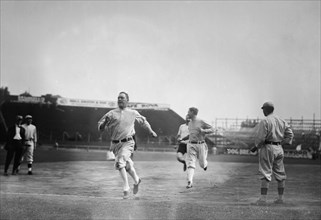Hick Cady of Boston Red Sox wins foot race with Jack O'Brien (Boston Red Sox trainer, pin shorts, partially obscured) and teammate Buck O'Brien (looking to his right) at Fenway Park, Boston (baseball)...