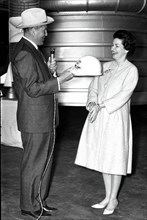 Marshall Space Flight Center Director Dr. Wernher von Braun presents Lady Bird Johnson with an inscribed hard hat during the First Lady's March 24, 1964 visit.