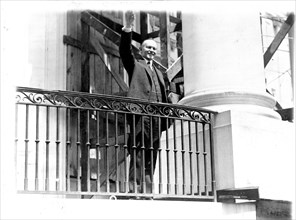 President Coolidge waving a greeting to the throngs of children gathered in the White House grounds to roll Easter eggs April 18, 1927