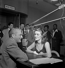 Tommy Dorsey (left) interviews the English pigeon, Beryl Davis, for his first disc jockey stint, with such names as Georgie Auld, Ray McKinley, Mary Lou Williams, Josh White and others visible in the ...