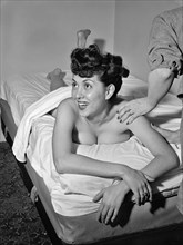 Portrait of Gloria King receiving a massage ca. Apr. 1947