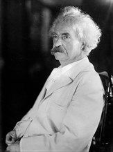 Samuel Clemens (Mark Twain) seated in chair