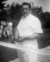 Photograph shows Irish American tenor singer John McCormack (1884-1945) holding a tennis racquet