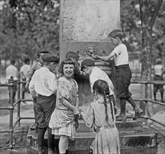 Children cooling themselves off in a fountain on a hot summer day in New York City ca. 1910-1915