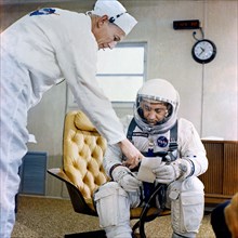 (23 March 1965) Astronaut Virgil I. Grissom, command pilot of the Gemini-Titan 3 space flight, is shown in the suiting trailer at Pad 16 going over a checklist with suit technician Joe Schmitt.