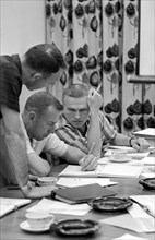 (2 Dec. 1965) Gemini-7 astronauts James Lovell Jr. (center) and Frank Borman (right) review mission requirements for their Gemini-7 flight.