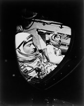 (23 March 1965) This view of astronauts John W. Young (left), pilot, and Virgil I. Grissom, command pilot, was taken through the window of the open hatch on Young's side of the Gemini-Titan 3 spacecra...