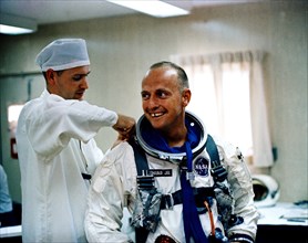 (12 July 1965) Astronaut Charles Conrad Jr. receives assistance with his pressure suit during suiting up and ingress test activity at Pad 16, Cape Kennedy, Florida in preparation for Gemini-5 spacefli...