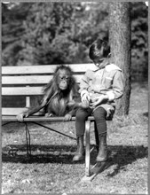 Boy seated with orangutan on bench at the National Zoo, Washington, D.C. ca. 1909-1932