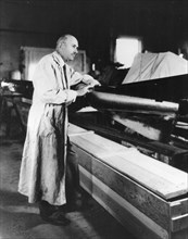 Robert Goddard with a rocket in his workshop at Roswell, NM. October 1935.