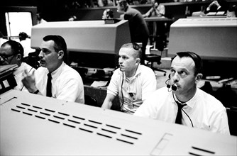 Shown at their consoles during the liftoff of Gemini-4 (from left) are astronauts Clifford C. Williams Jr., Frank Borman and Alan B. Shepard Jr.