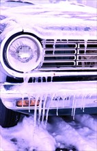 Headlamp of an automobile and icicles on a car in the late 1960s