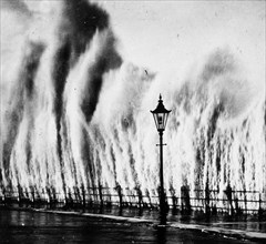 Waves striking seawall give appearance of geysers erupting ca. 1938
