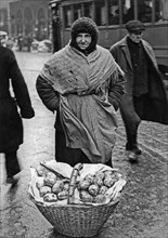 A woman selling paczki (filled doughnuts) in a street in Warsaw ca. December 1934