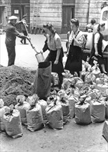 Warsaw Uprising: Filling of sand bags by civilian population in the courtyard of townhouse at Moniuszki 11 street ca. August 1944