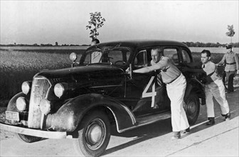 International Rally Automobile Club Poland, Grand Prix Poland 1937, new Chevrolet Master Sedan with his driver Witold Rychter and pilot Jerzy Wedrychowski. Car is not damaged. They are pushing their c...