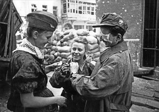 Warsaw Uprising: Two medics and a soldier (right) from "Parasol" battalion after coming out of sewers at Warecka Street near Nowy Swiat (North Sródmiescie district). In the center Maria Stypulkowska-C...