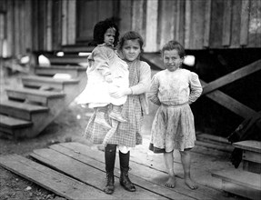 Millie, (about 7 years old) and Mary John (with baby) 8 years old. Both shuck oysters. This is Mary's second year, February 1911