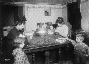 Picking nuts in dirty basement, December 1911 Picking nuts in dirty basement. The dirtiest imaginable children were pawing over the nuts eating lunch on the table