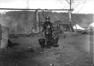 Shorpy; a greaser on the tipple at Bessie Mine, Alabama. Carries two heavy pails of grease and is often in danger of being run over by the cars, November 1910