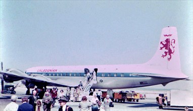 Israel April 1965:  Passengers departing from a Caledonian Airways airplane (probably a DC-7) at an unidentified airport in Israel