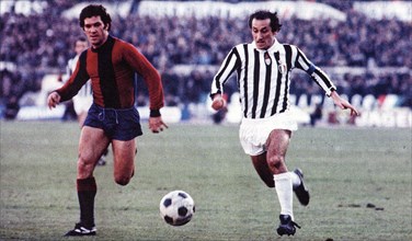 Franco Nanni from Bologna (left) and Giuseppe Furino from Juventus (right) chase the ball during a match between Bologna and Juventus ca. 1975-1978