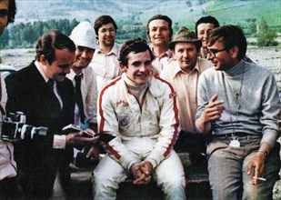 Belgian car driver Jacky Ickx (in the center), and the Italian engineer and builder Gian Paolo Dallara (on the right), in a conversation on the Varano de 'Melegari circuit ca. late 1960s or early 1970...