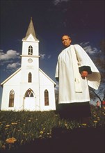 Rev. David T. Ernst stands near his church, the Immanuel Lutheran, in Plymouth Nebraska. Church is 70 years old, May 1973