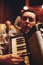 Closeup of an Accordionist Who Accompanies the Concord Singers as They Practice Singing German Songs in New Ulm Minnesota... ca. 1975