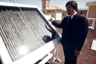 Dr. R. L. San Martin, New Mexico State University, Las Cruces shows an experimental solar panel being tested..., 04 1974