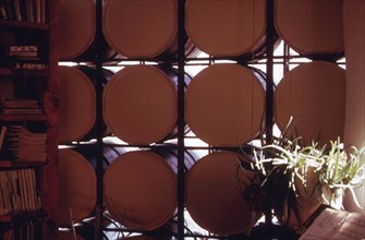 Interior detail of 55-gallon water filled drums that form the core of the passive solar heating system of this home near Corrales, New Mexico... 04 1974