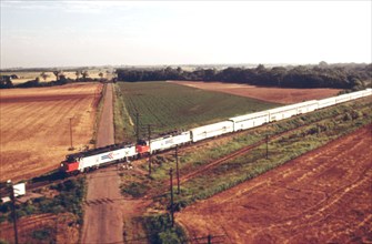 The Lone Star (train #15) is shown from the air as it passes a typical rural Oklahoma crossing between guthrie and norman enroute from Chicago to Houston, Texas, June 1974
