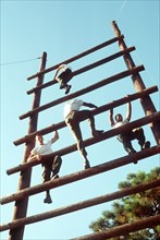 1978 - Soldiers climb a large wooden ladder while on an obstacle course.