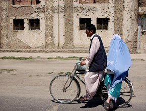 2002 - An Afghani couple rides a bicycle through the streets of Kabul, Afghanistan