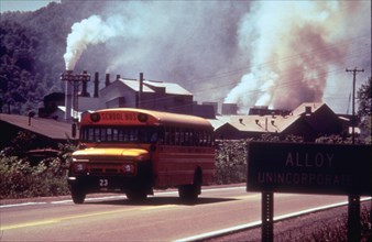 1970s - school bus driving down road in front of polluting factory (possibly Alloy, West Virginia)