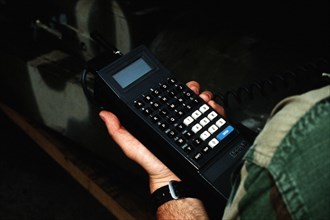 A Marine holds a small computer