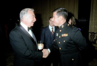 A Marine Corps major shakes hands with Walter Cronkite